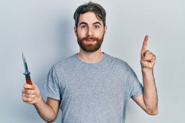 Sakallı, elinde çakı olan beyaz bir adam bir fikre ya da soru işaretine şaşırdı. 