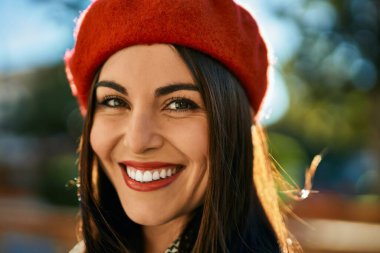 Genç İspanyol kadın gülümseyerek şehirde mutlu mesut dikiliyor..