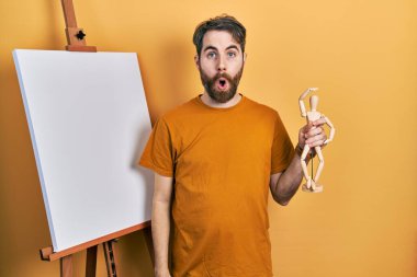 Beyaz sakallı, boyacı sehpasının yanında duran beyaz adam elinde manikinle korkmuş ve ağzı açık bir şekilde şaşırmış, inançsız bir yüz ifadesi vardı. 