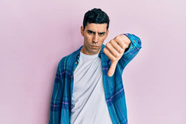 Yakışıklı, sıradan kıyafetler giyen, mutsuz görünen, reddedilmiş ve olumsuz davranan yakışıklı bir İspanyol. kötü ifade. 