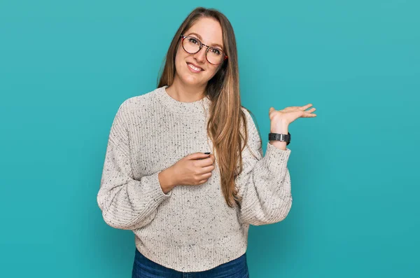 Mujer Rubia Joven Vistiendo Suéter Casual Gafas Sonrientes Alegre Presentando —  Fotos de Stock