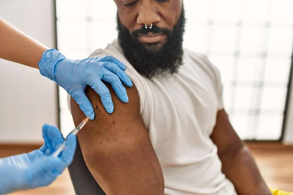 在诊所向非洲裔美国男子注射Covid 19疫苗的护士手 — 图库照片