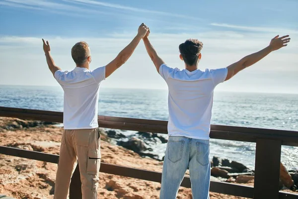 一对年轻的同性恋夫妇在后视镜下眺望海滩上的地平线 — 图库照片