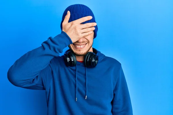 Latynoski Młodzieniec Bluzie Słuchawkach Uśmiechający Się Śmiejący Ręką Twarzy Zakrywający — Zdjęcie stockowe