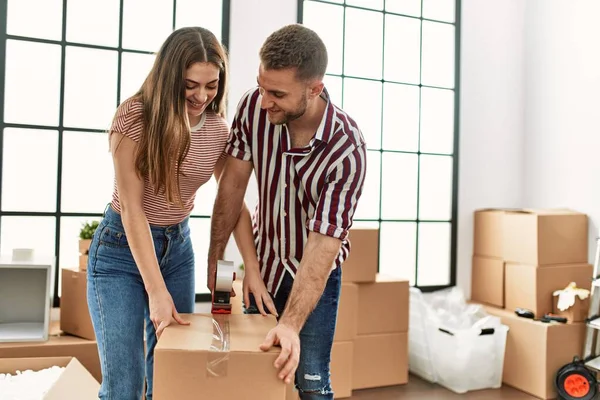 Joven Pareja Hispana Sonriendo Feliz Embalaje Caja Cartón Nuevo Hogar —  Fotos de Stock