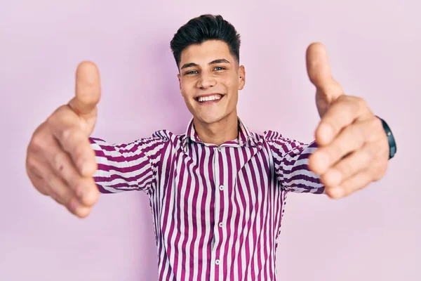 Молодий Іспаномовний Чоловік Повсякденному Одязі Дивиться Камеру Посміхаючись Відкритими Руками — стокове фото