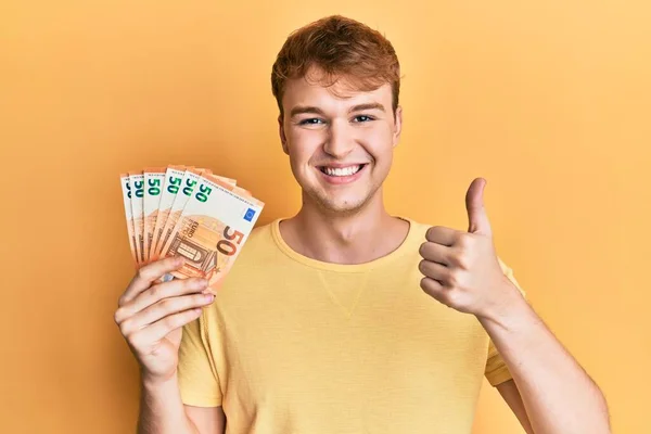 Молодий Кавказький Чоловік Тримає Купу Банкнот Євро Посміхаючись Щасливим Позитивним — стокове фото