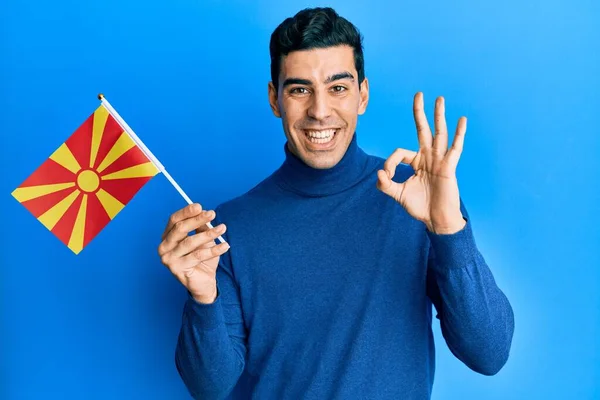 Handsome Hispanic Man Holding Macedonian Flag Doing Sign Fingers Smiling — Stock Photo, Image
