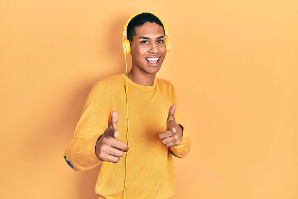 Young African American Guy Listening Music Using Headphones Pointing Fingers — Stock Fotó