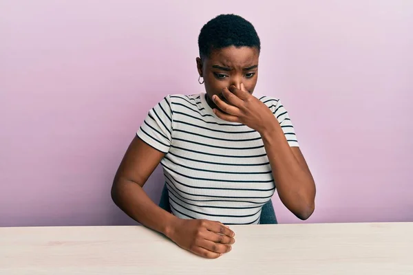 Jovem Afro Americana Vestindo Roupas Casuais Sentada Mesa Cheirando Algo — Fotografia de Stock