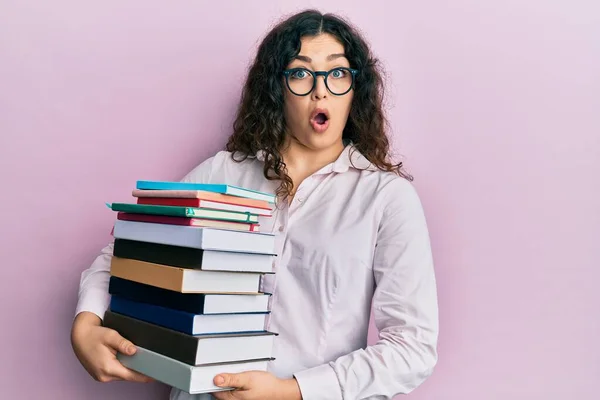 Young Brunette Woman Curly Hair Holding Pile Books Afraid Shocked — Stock Photo, Image