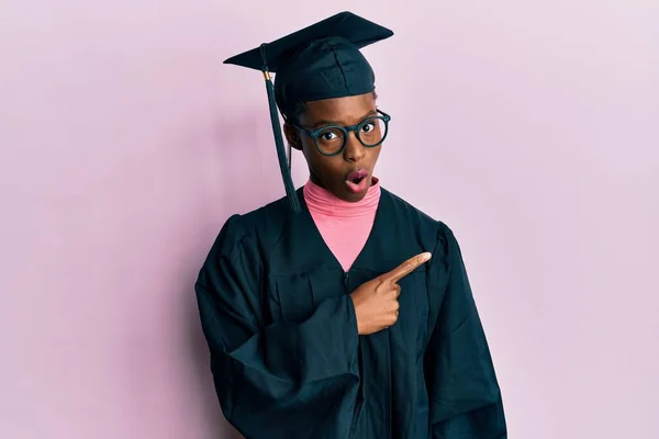 Junge Afrikanisch Amerikanische Mädchen Mit Abschlussmütze Und Zeremoniengewand Überrascht Zeigt — Stockfoto