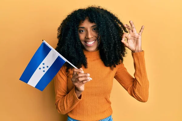 Африканская Американка Афроволосами Держащая Флаг Гондураса Делает Знак Пальцами Улыбаясь — стоковое фото
