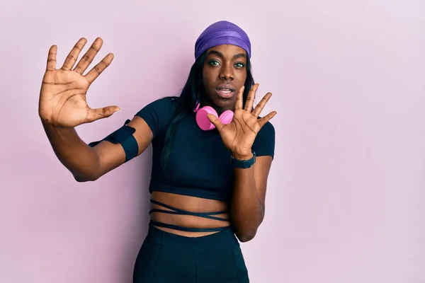 Young African American Woman Wearing Gym Clothes Using Headphones Afraid — Zdjęcie stockowe