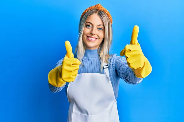Beautiful Blonde Woman Wearing Cleaner Apron Gloves Approving Doing Positive — Stok Foto