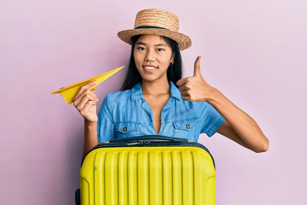 Young Chinese Woman Holding Cabin Bag Paper Plane Smiling Happy — Stockfoto