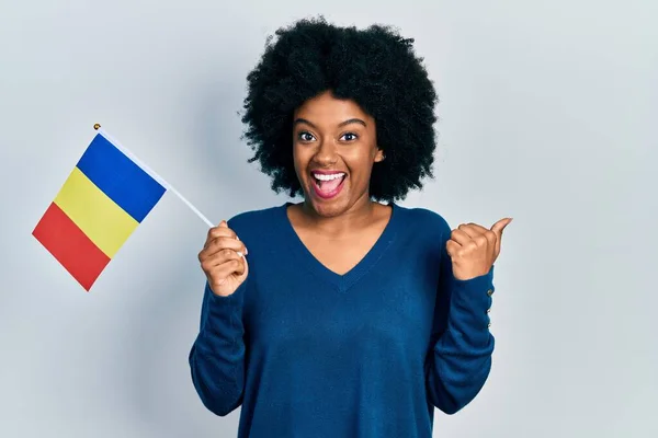 Young African American Woman Holding Romania Flag Pointing Thumb Side — Stockfoto