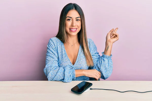 Young Hispanic Woman Wearing Casual Clothes Charging Smartphone Battery Smiling — Zdjęcie stockowe