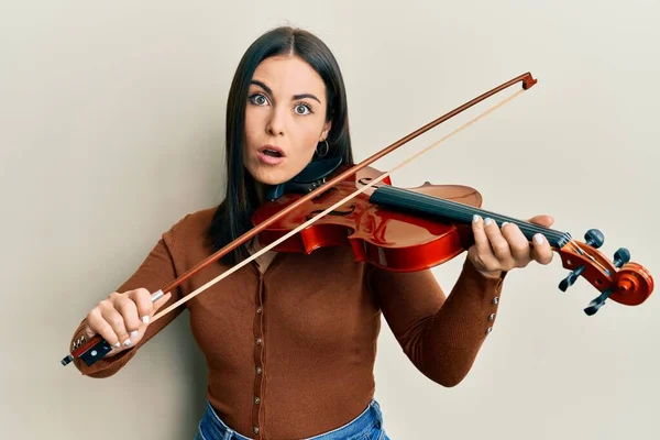 Young Brunette Woman Playing Violin Afraid Shocked Surprise Amazed Expression — Stock Photo, Image