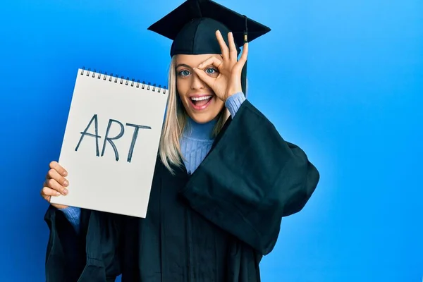 Beautiful Blonde Woman Wearing Graduation Cap Ceremony Robe Holding Art — Zdjęcie stockowe