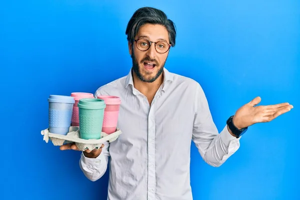 Joven Hispano Sosteniendo Bandeja Con Café Para Llevar Celebrando Logro —  Fotos de Stock