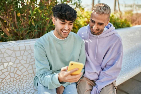 在城市里 一对年轻的同性恋夫妇用智能手机开心地笑着 — 图库照片