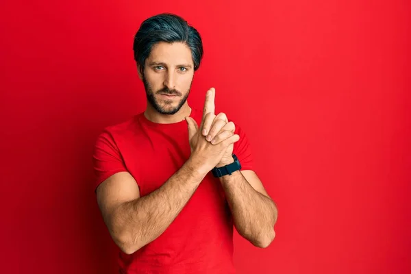 Young Hispanic Man Wearing Casual Red Shirt Holding Symbolic Gun — Stock Photo, Image