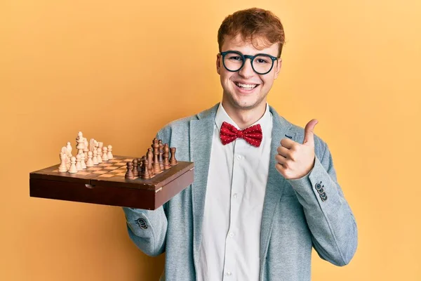 Young Caucasian Man Wearing Glasses Holding Chess Board Smiling Happy —  Fotos de Stock