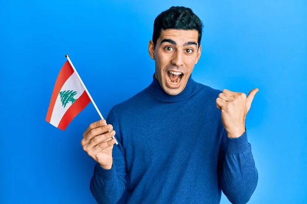 Handsome Hispanic Man Holding Lebanon Flag Pointing Thumb Side Smiling — 스톡 사진