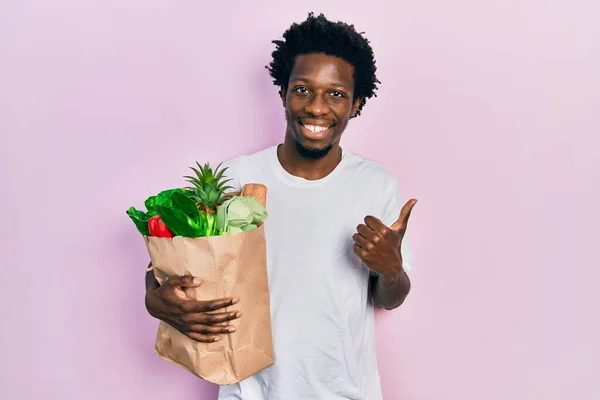 Joven Afroamericano Hombre Sosteniendo Bolsa Papel Con Pan Comestibles Sonriendo —  Fotos de Stock