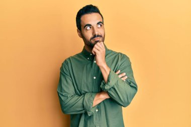 Gündelik kıyafetler giyen genç İspanyol adam şüphe üzerine yoğunlaşmıştı. Parmakları çenesinde ve yukarı bakıyordu. 