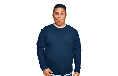 Gündelik kıyafetler giyen genç latin adam dudaklarıyla balık suratı yapıyor, çılgınca ve komik bir jest. Komik ifade. 