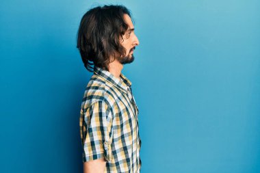 Latin kökenli genç adam rahat bir görünüm takınıyor, rahat bir görünüm takınıyor, kendine güvenen bir gülümsemeyle.. 