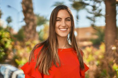 Genç İspanyol kadın parkta mutlu bir şekilde gülümsüyor..