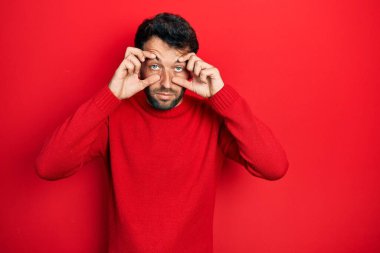 Sakallı, sıradan kırmızı süveter giyen, gözlerini parmaklarıyla açmaya çalışan, uykulu ve yorgun, sabah yorgunluğu çeken yakışıklı adam. 