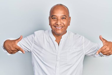 Orta yaşlı, gündelik kıyafetler giyen, kendine güvenen, gülümseyen, kendini gururlu ve mutlu gösteren bir adam.. 