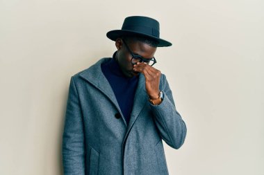 Genç Afro-Amerikan erkeği şık giyinmiş. Burnu ve gözleri ovuşturmaktan yorulmuş. Yorgun ve baş ağrısı çekiyor. Stres ve hüsran kavramı. 