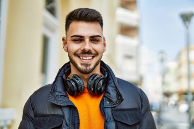 Yakışıklı, sakallı, neşeli ve kendine güvenen, kışlık palto giyen bir İspanyol.