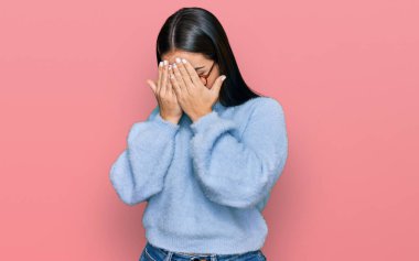 Genç İspanyol kadın gündelik kıyafetler ve ağlarken suratını ellerle kapatan üzgün yüzlü gözlük takıyor. depresyon kavramı. 