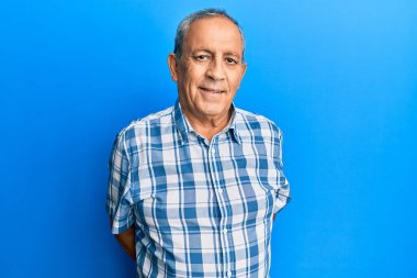 Yüzünde mutlu ve havalı bir gülümseme olan günlük kıyafetler giyen İspanyol kıdemli adam. şanslı kişi. 