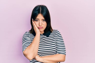 Gündelik kıyafetler giyen genç İspanyol kadın kollarını kavuşturarak depresyondan sıkılmış ve yorgun görünüyor.. 