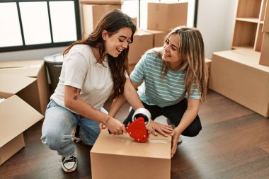 Genç ve güzel bir çift gülümsüyor. Yeni evlerinde karton kutular paketliyorlar..