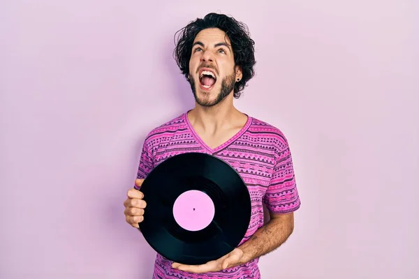 Handsome Hispanic Man Holding Vinyl Disc Angry Mad Screaming Frustrated — Stock Photo, Image