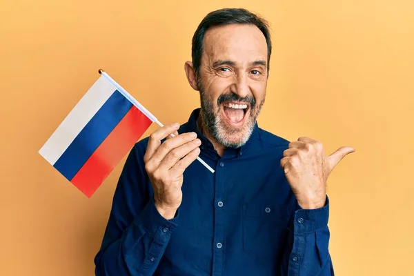 Middle Age Hispanic Man Holding Russia Flag Pointing Thumb Side — Photo