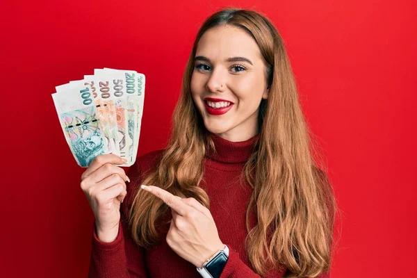 Joven Mujer Rubia Sosteniendo Billetes Coronas Checas Sonriendo Feliz Señalando —  Fotos de Stock