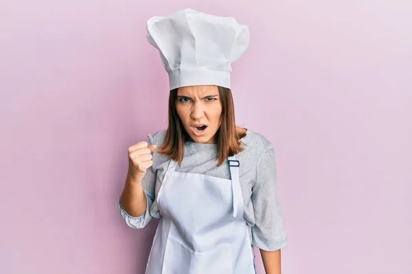 プロの料理人の制服を着た若い美少女は怒りながら叫びながら怒りと怒りのあまり拳を上げて激怒 怒りと攻撃的な考え方 — ストック写真
