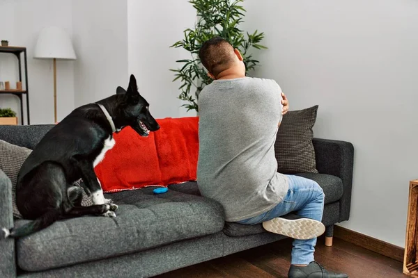 Young Latin Man Dog Sitting Sofa Home Hugging Oneself Happy — 图库照片