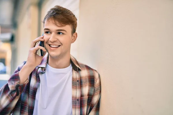 若い白人男性は 市内のスマートフォンで幸せな話を笑っています — ストック写真