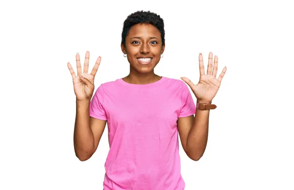 自信を持って幸せな笑顔ながら 若いアフリカ系アメリカ人の女性は カジュアルな服を着て指番号9で示すと指摘します — ストック写真