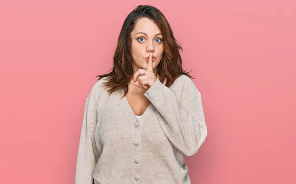 若いプラスサイズの女性が唇に指で静かにするように求めるカジュアルな服を着て 沈黙と秘密の概念 — ストック写真
